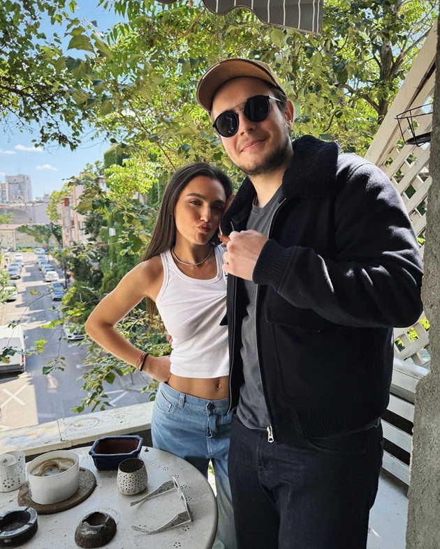 Alexia Eram stâns în spatele fratelui său, Aris Eram, pe balcon
