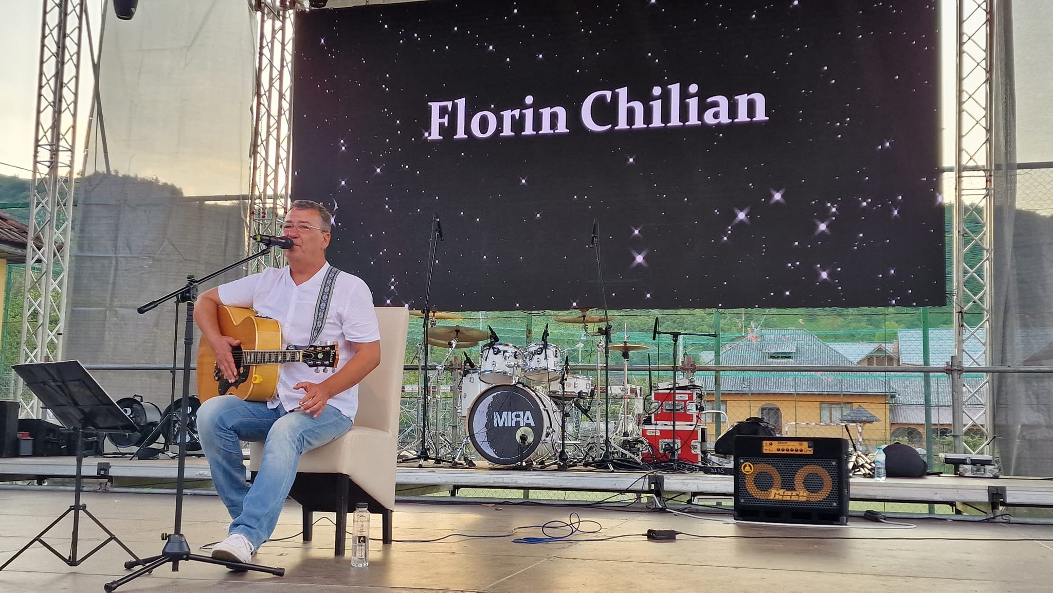 Florin Chilian pe scenă, cântând la chitară în fața publicului său, în timpul unui concert