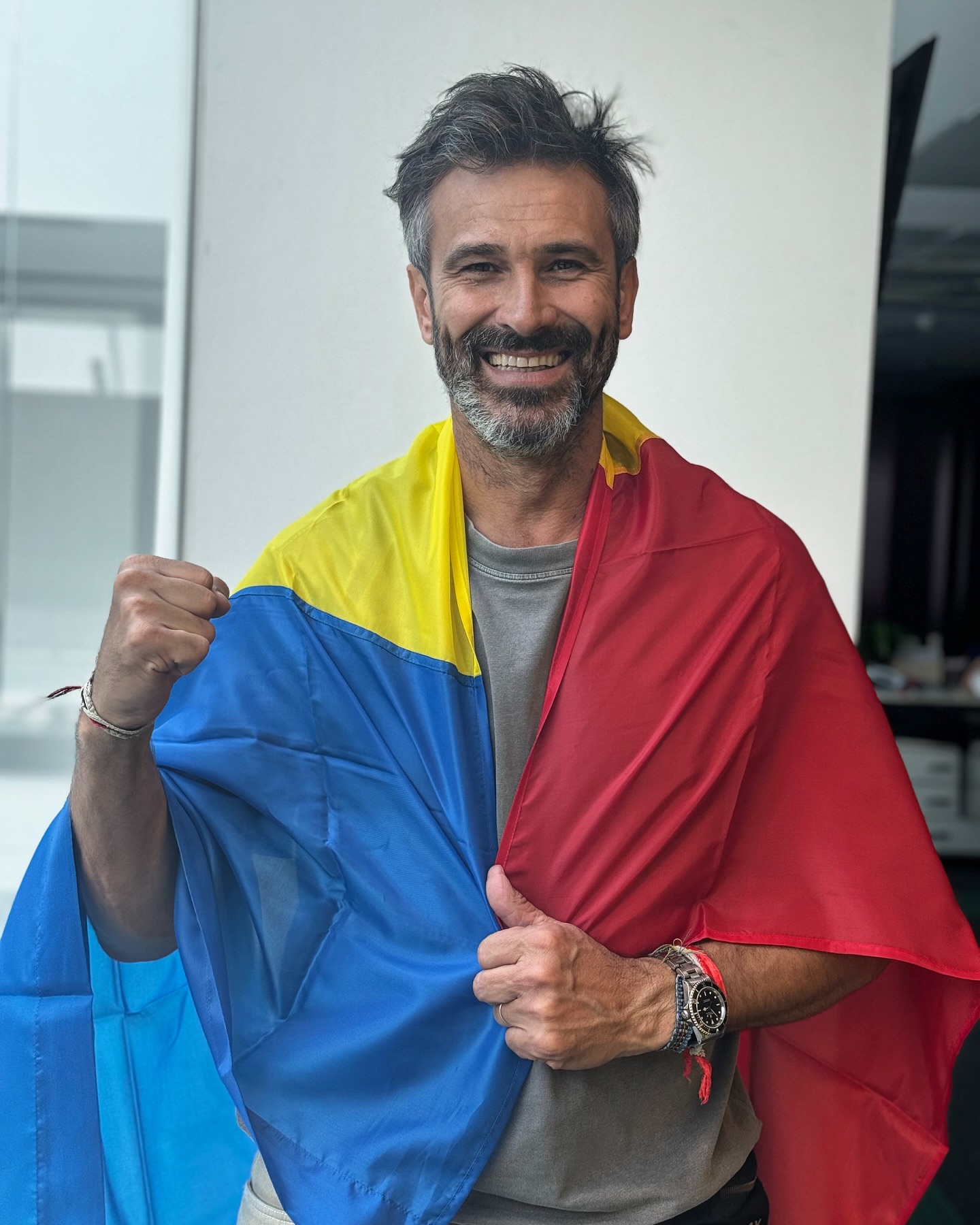 Nicolai Tand zâmbitor, purtând drapelul României pe umeri