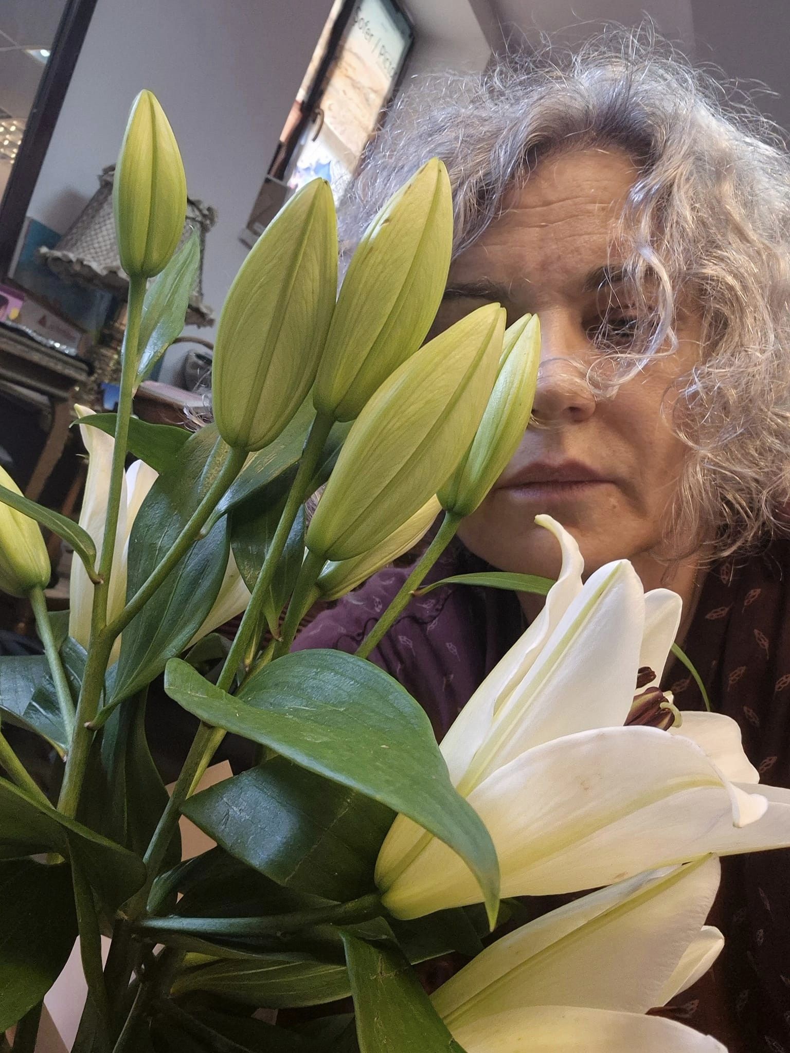 Maia Morgenstern nostalgică, ținând în fața chipului ei crinii albi luați pentru regretata sa mamă