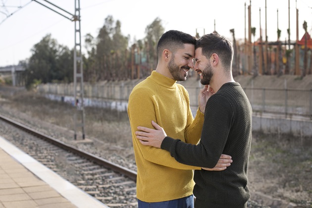 Cuplu de bărbați care se îmbrățișează și își sprijină frunțile una de alta