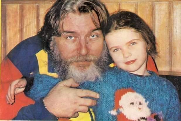 Ana Maria Păunescu în copilărie, îmbrăcată într-un pulover cu Moș Crăciun, strânsă în brațe de tatăl ei, Adrian Păunescu