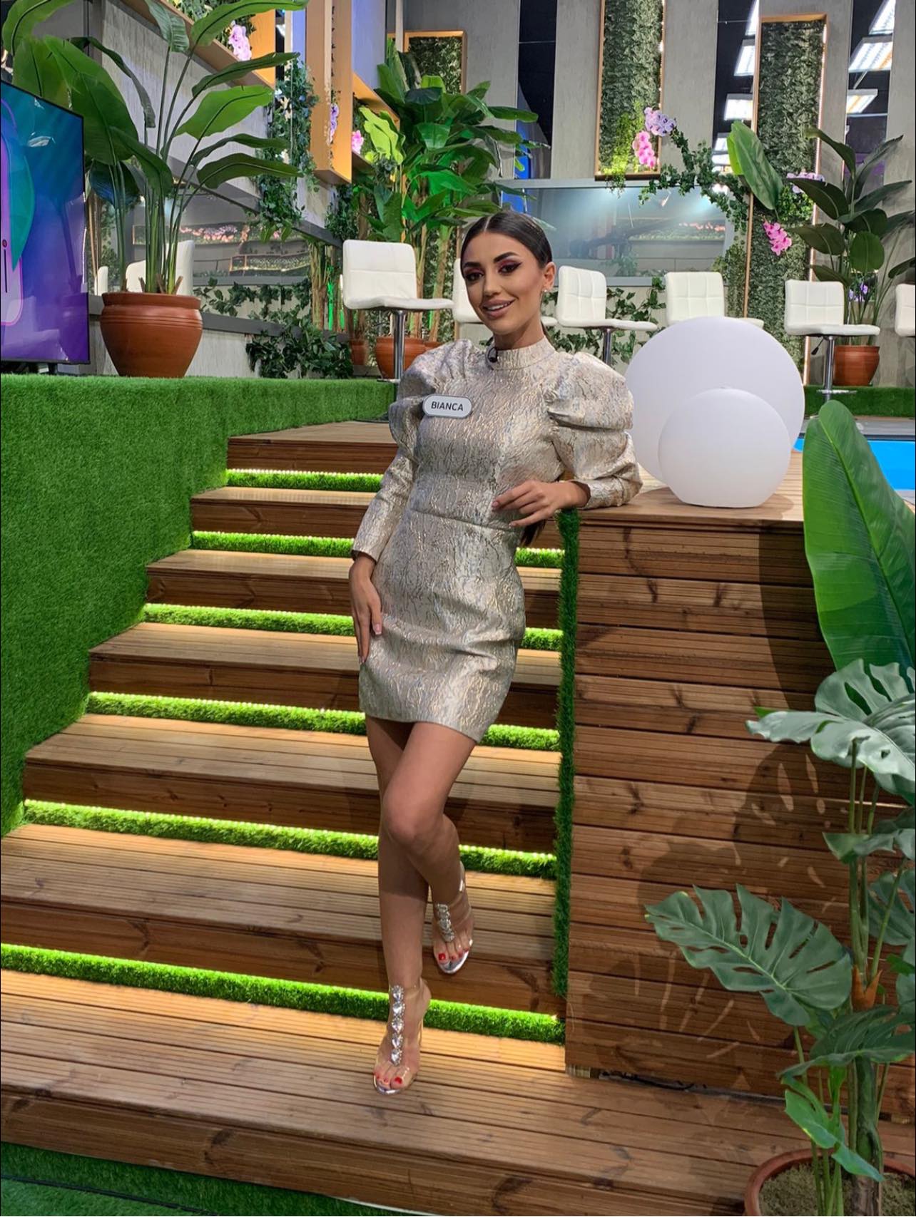 Bianca Mitroi într-o rochie argintie, cu părul prins, în platoul emisiunii Casa Iubirii