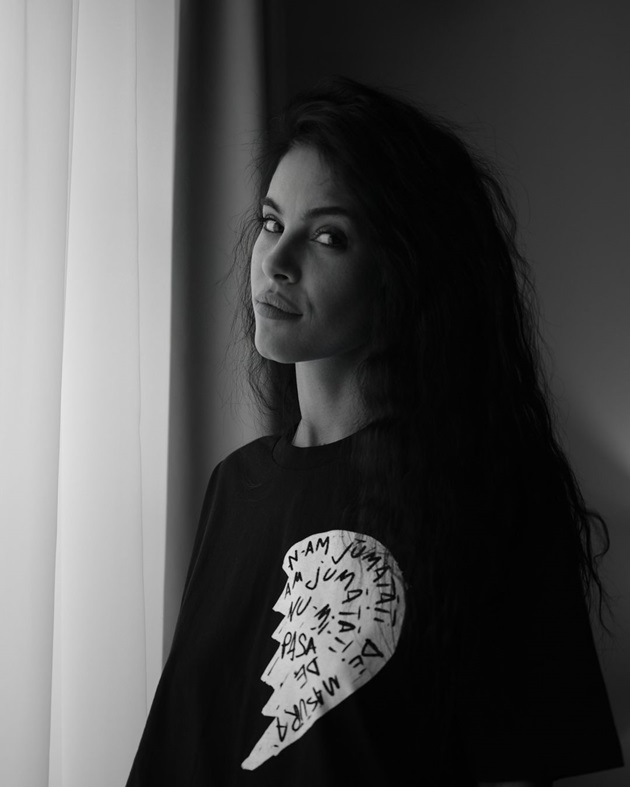 Imagine alb-negru cu Livia Eftimie, îmbrăcată într-un tricou negru care are pe el o jumătate de inimă albă