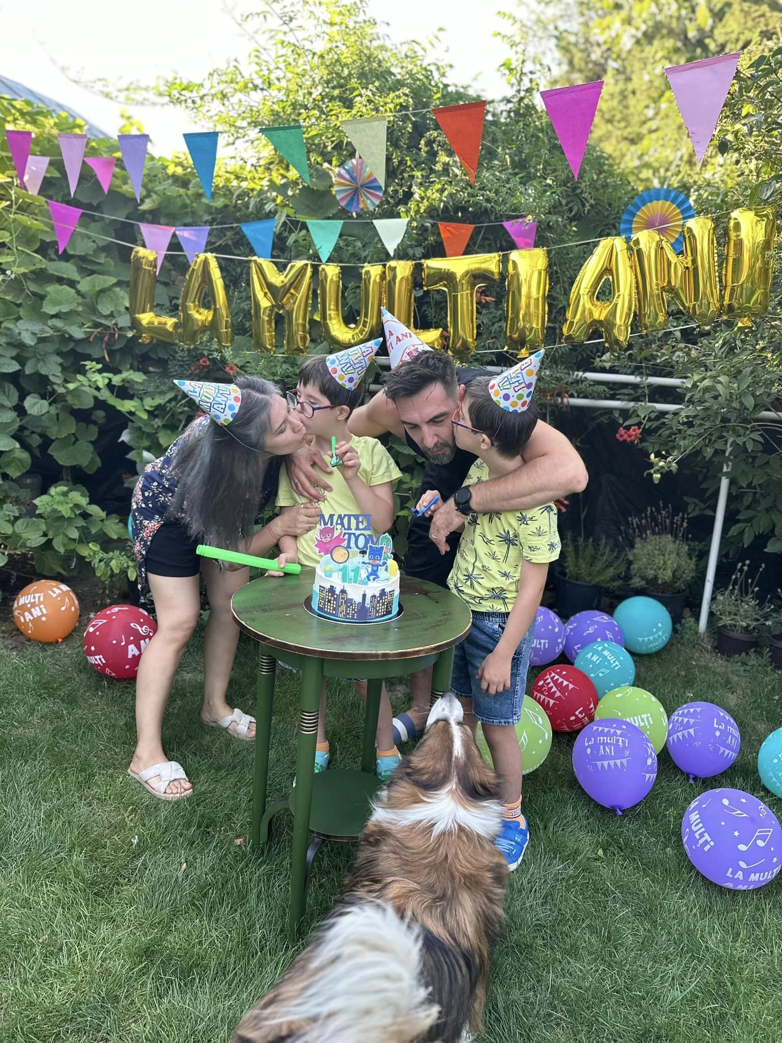 Cristina Bălan și soțul ei sunt pupați pe obraz de gemenii lor care au împlinit 11 ani, fotografie făcută la petrecerea lor aniversară, în timp ce purtau toți patru coifuri pe cap