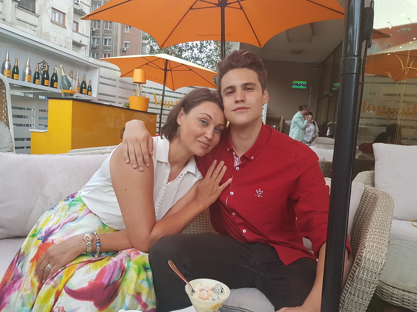 Daniela Nane, pe terasă, la o înghețată, cu fiul ei care o ține în brațe