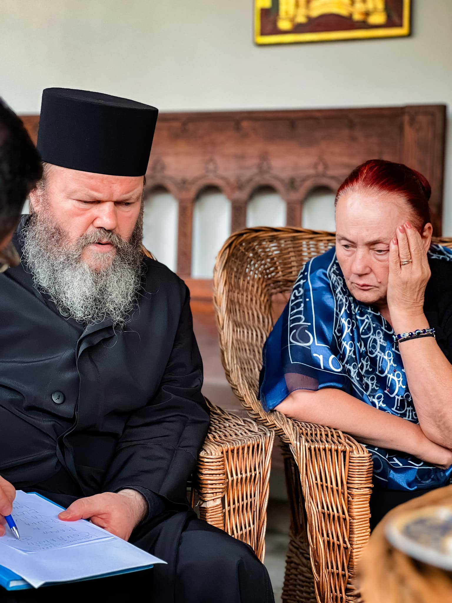 Rusalina Măruță, sprijinindu-și capul cu mâna, ascultând ce spune Starețul Ioachim de la Mănăstirea Lainici, într-o întâlnire ce a avut loc după decesul soțului ei