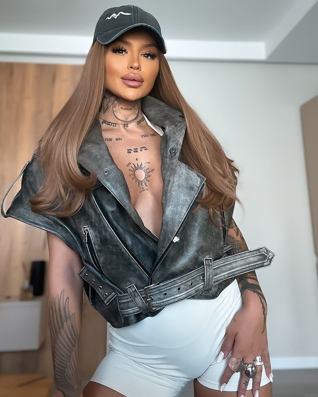 Diandra Moga în hainele create de ea, purtând perucă și șapcă pe cap