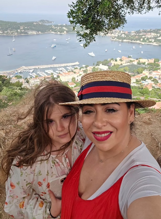 Oana Roman în vacanță, la mare, purtând pălărie, cu fiica ei Isabela