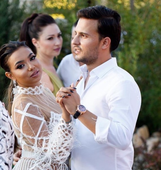 Adriana Simionescu îmbrăcată într-o rochie albă, în timp ce dansează cu soțul ei, îmbrăcat și el în alb