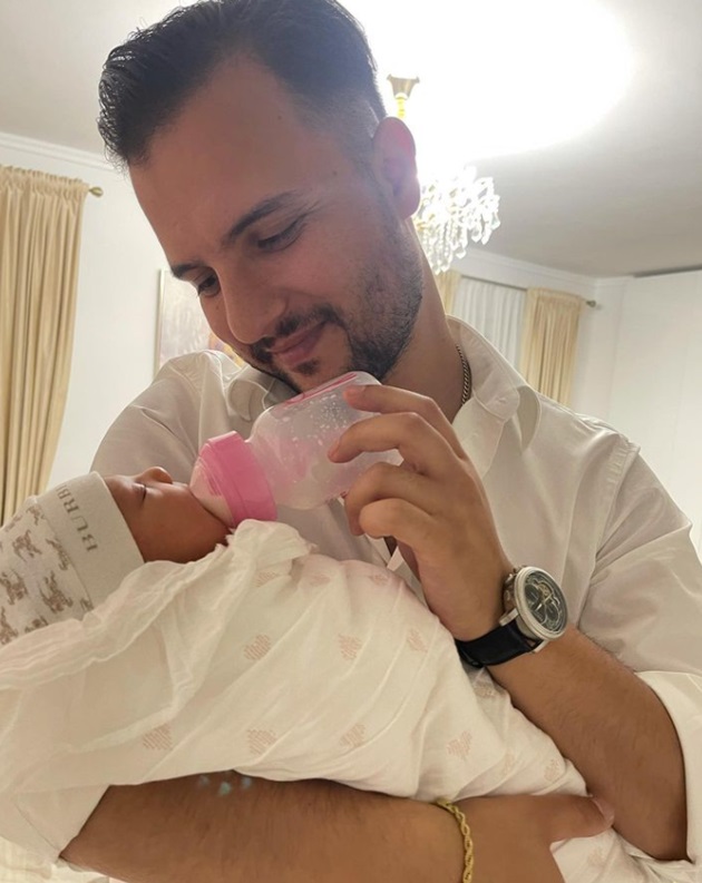 Soțul Adrianei Simionescu fericit, în timp ce o hrănește cu biberonul pe fiica lor, Noa Zenayda