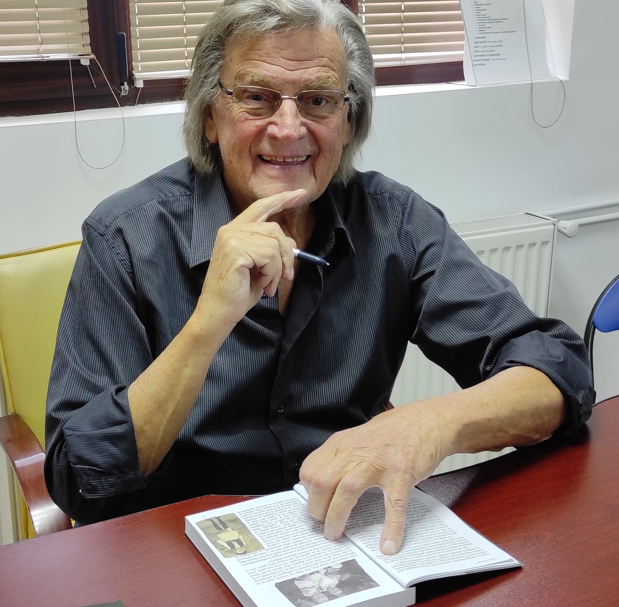 florin piersic scrie intr-o agenda si zambeste spre camera