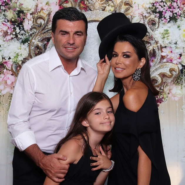 Simona Pătruleasa alături de soțul și de fiica ei, la un eveniment, stând la panoul foto, cu o pălărie deasupra capului
