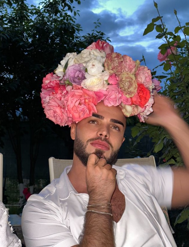 Bassam Dabbas purtând o coroană mare de flori pe cap