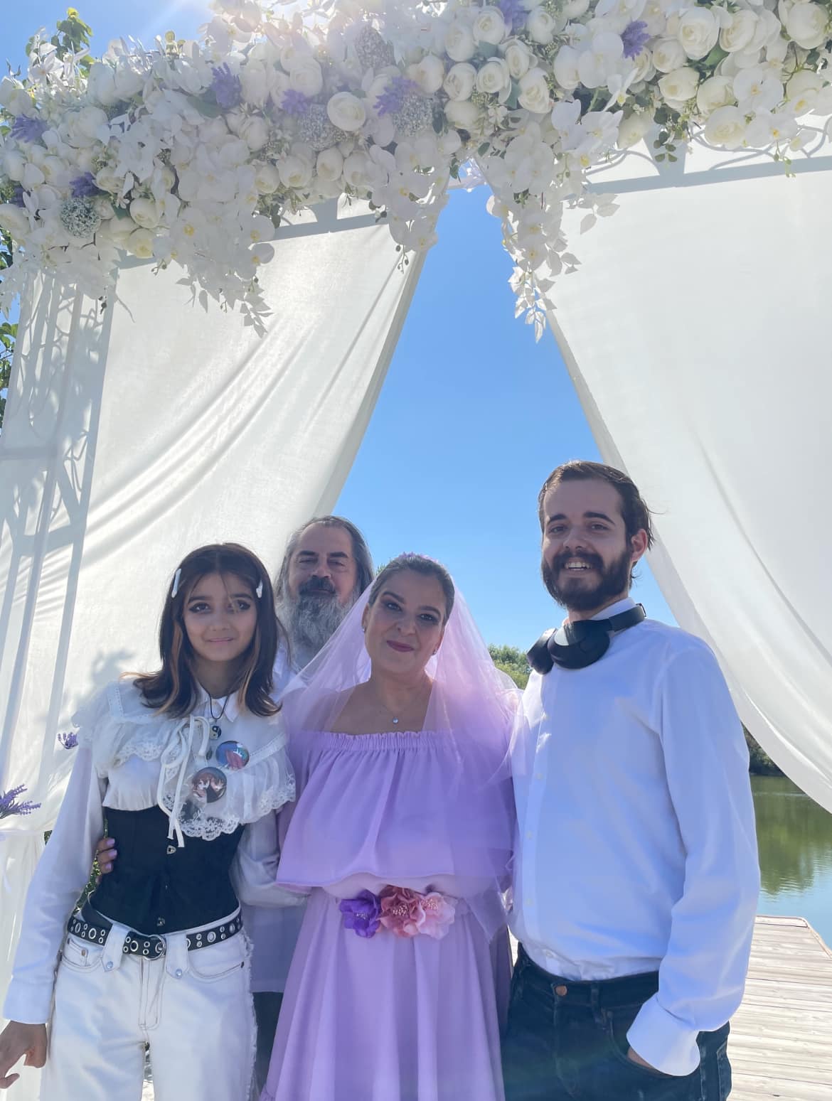 Nouria Nouri alături de actualul soț și de copiii care i-au fost alături în ziua cununiei, stând toți sub decorul cu flori albe