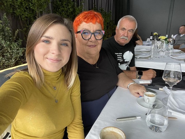 Cristina Ciobănașu la masa unui restaurant, alături de părinții ei adoptivi