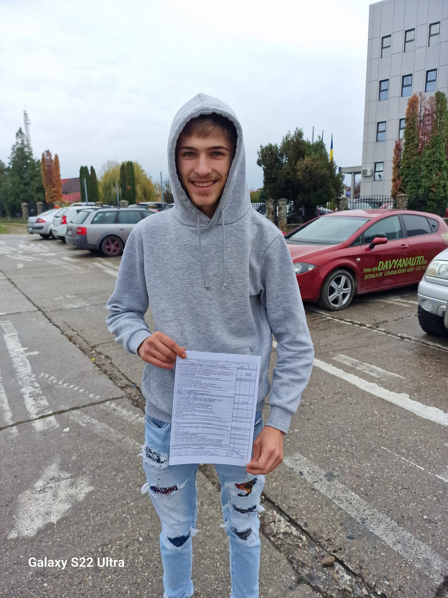 Paul Melinte zâmbitor, ținând în mână dovada care atestă că a obținut permisul de conducere