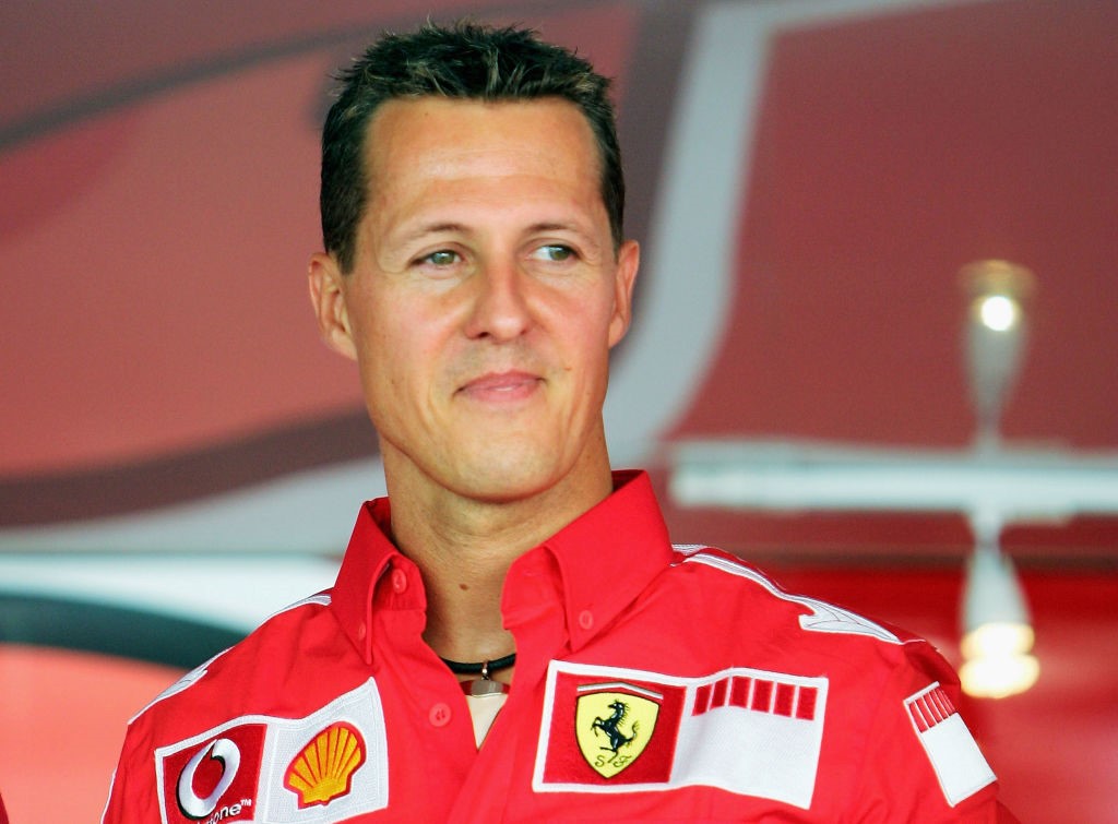 Fostul pilot Michael Schumacher la finalul unei curse, îmbrăcat în roșu și zâmbitor