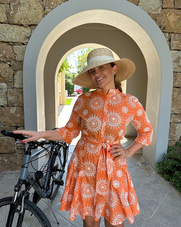 Cristina Șișcanu în vacanță, la o plimbare cu bicicleta, îmbrăcată în rochie portocalie și cu pălărie pe cap