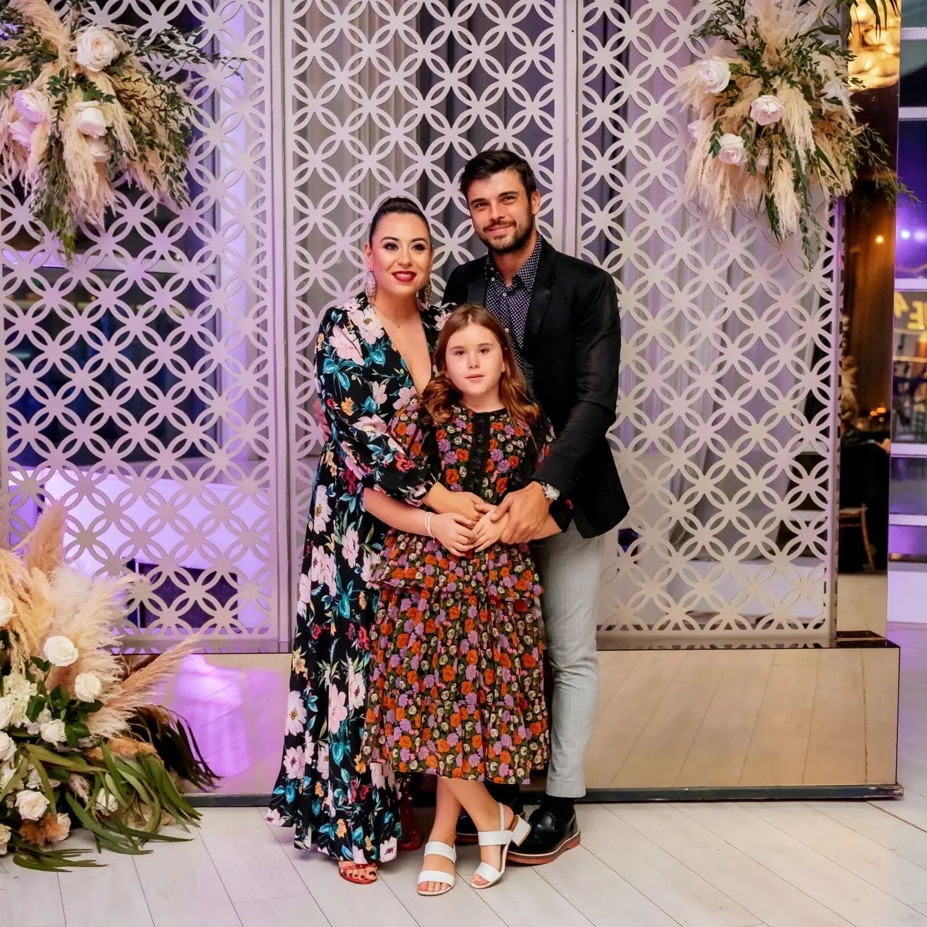 Oana Roman și Marius Elisei îmbrățișându-și fiica, la un eveniment, pe vremea când formau o familie