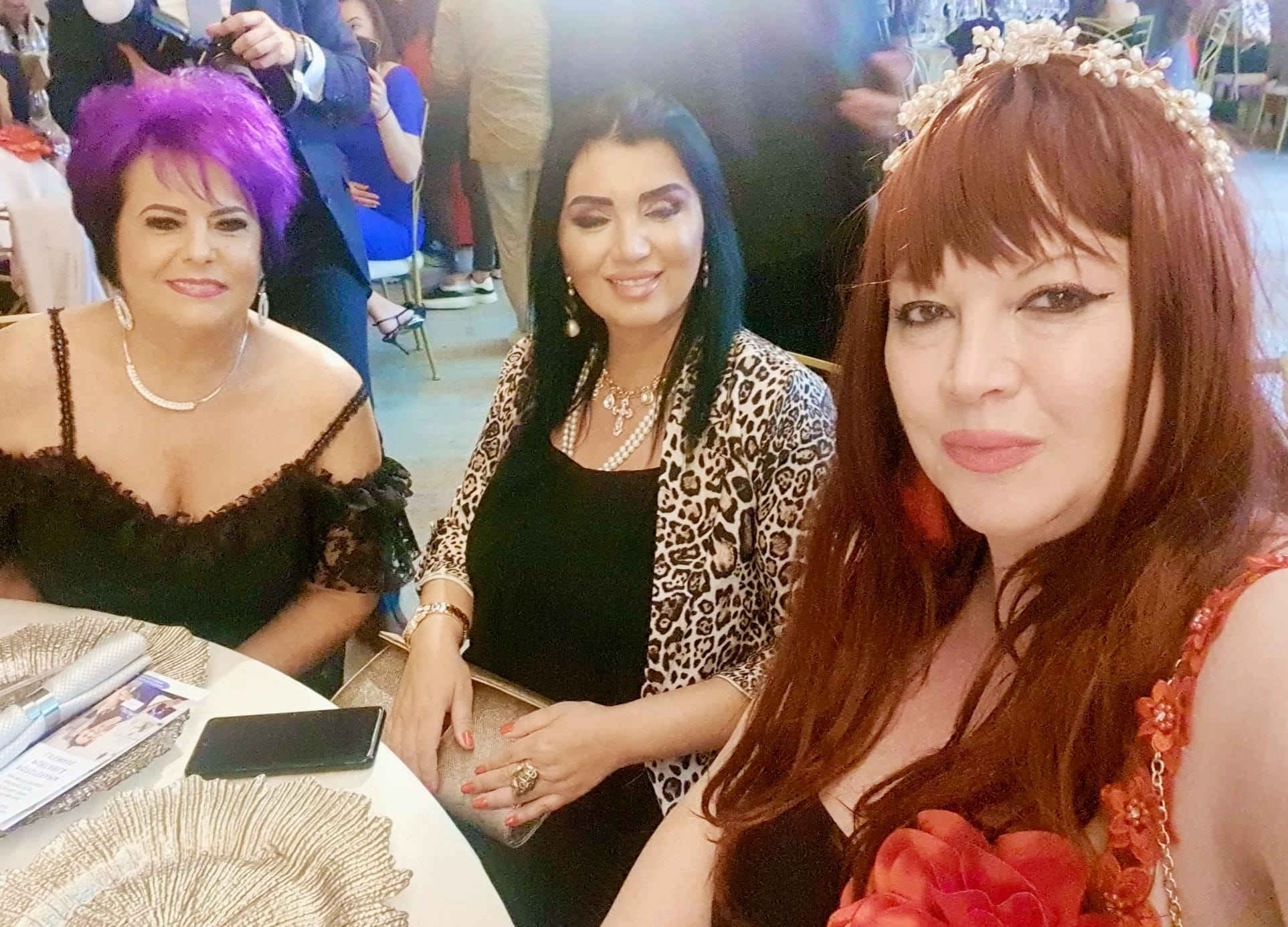 Oana Lis cu perucă roșcată la un eveniment, stând la aceeași masă cu Adriana Bahmuțeanu