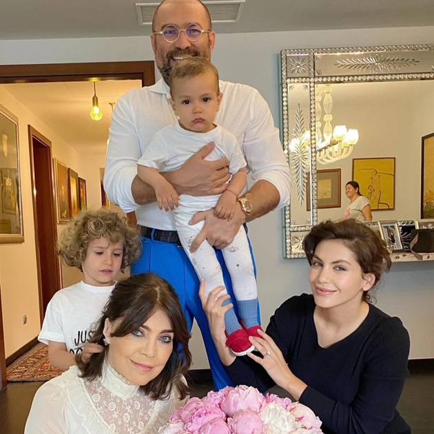 Delia Budeanu lângă un buchet mare de bujori, înconjurată de familie, de fiul ei, Radu Budeanu, de soția acestuia și de copiii lor