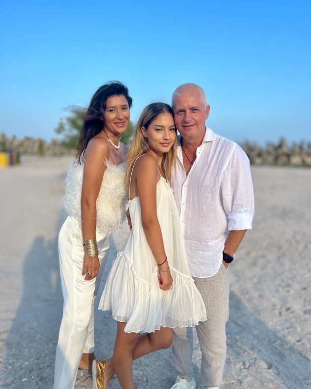 Virgil Ianțu pe plajă, îmbrăcat în alb, alături de soție și de fiică, îmbrăcate și ele în aceeași culoare