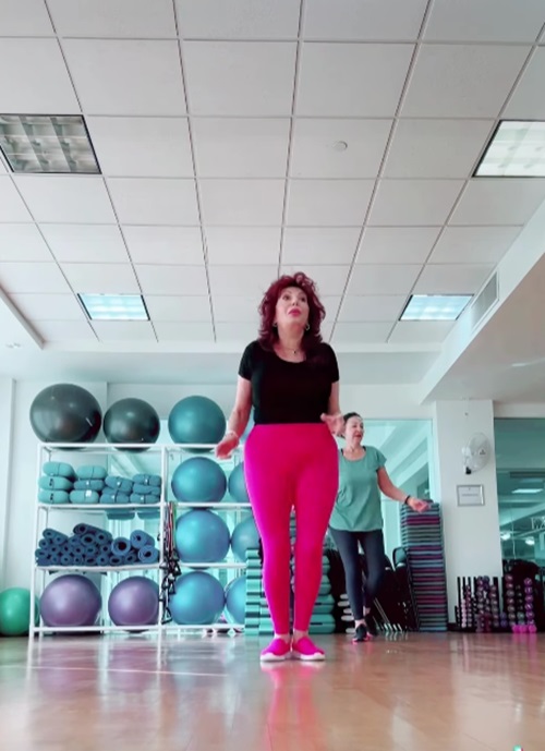 Carmen Harra dansând la ora de Zumba, în colanți roz și tricou negru