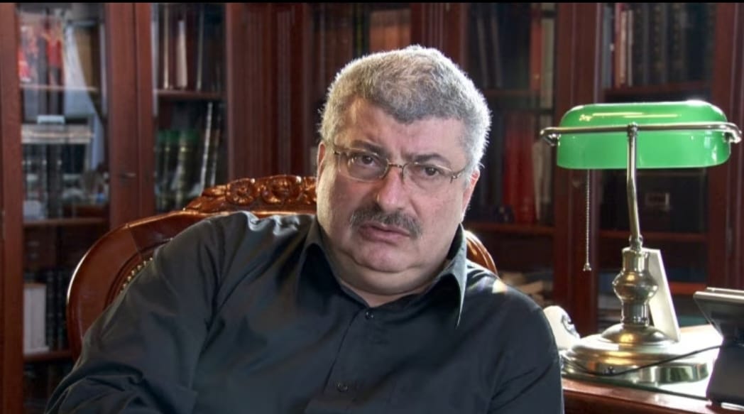 Silviu Prigoană stând pe un fotoliu în biroul casei sale din București