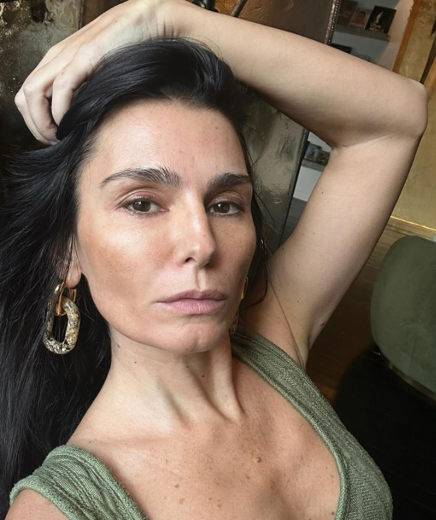 Dana Budeanu făcându-și un selfie în timp ce ține o mână în păr și poartă cercei mari aurii