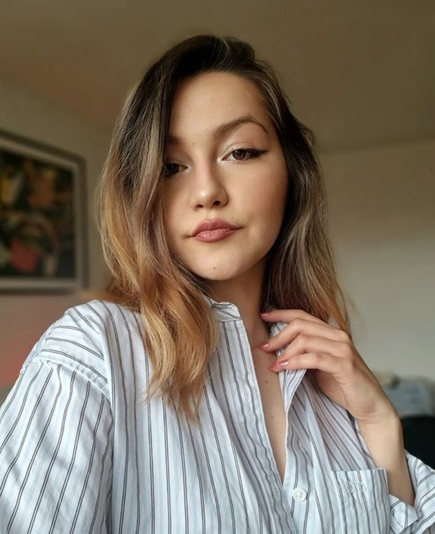 Oana Lasconi făcându-și selfie în timp ce era îmbrăcată cu o cămașă albă cu dungi gri
