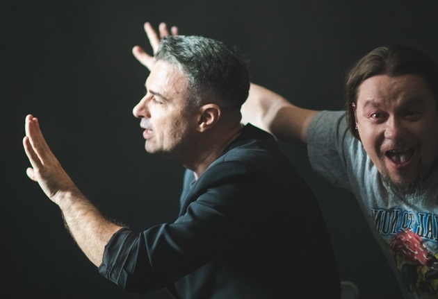 Cornel Ilie și Nicu Sârghea pe scenă, în mișcare, arătând cu mâinile într-o anumită direcție