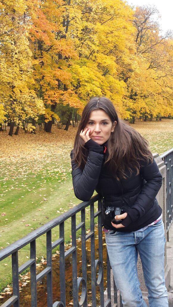 Ana Diaconu, fata lui Mircea Diaconu, într-un parc, toamna, sprijinită de un gard metalic