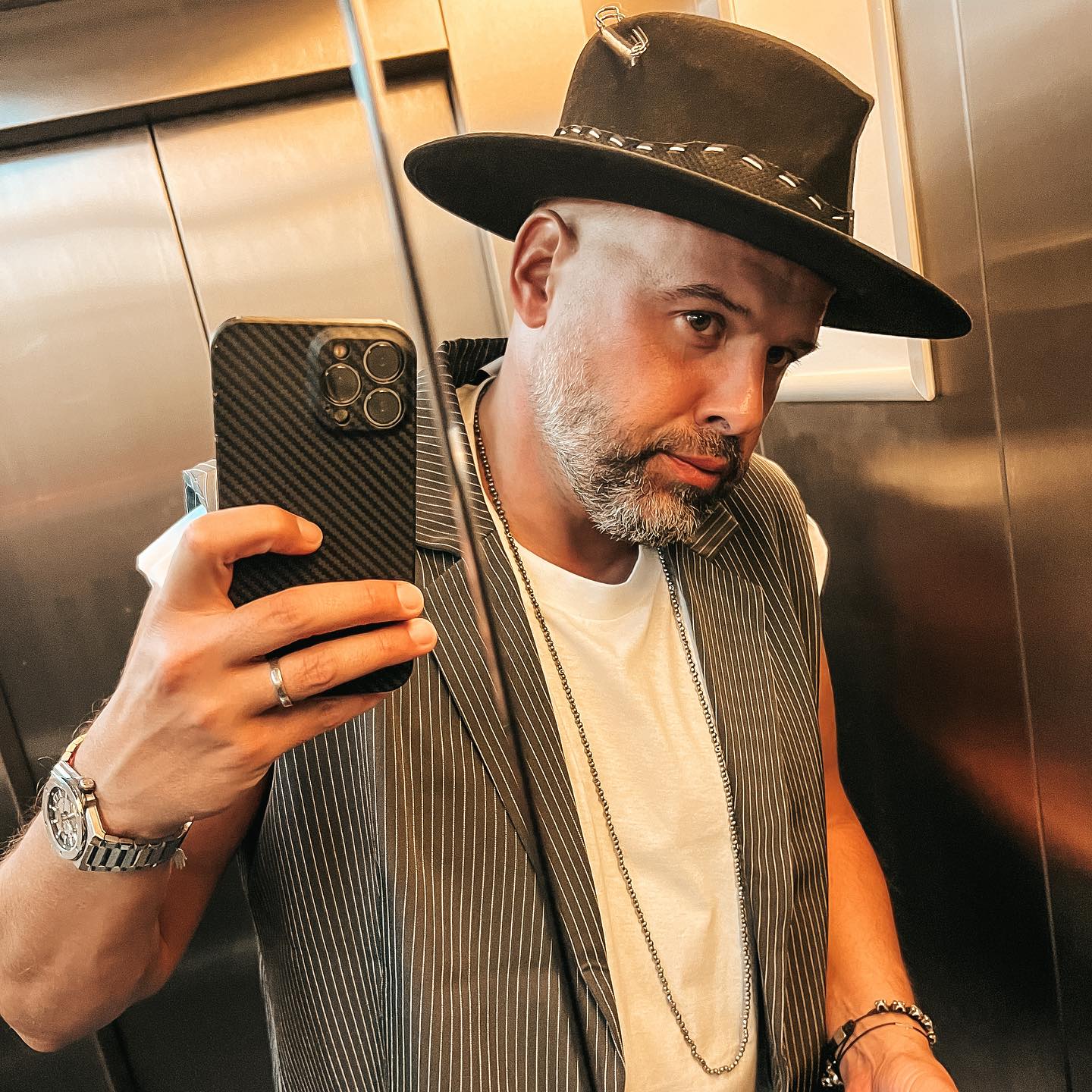 Tinu Vidaicu făcându-și o fotografie în oglinda din lift, în timp ce purta o pălărie maro pe cap