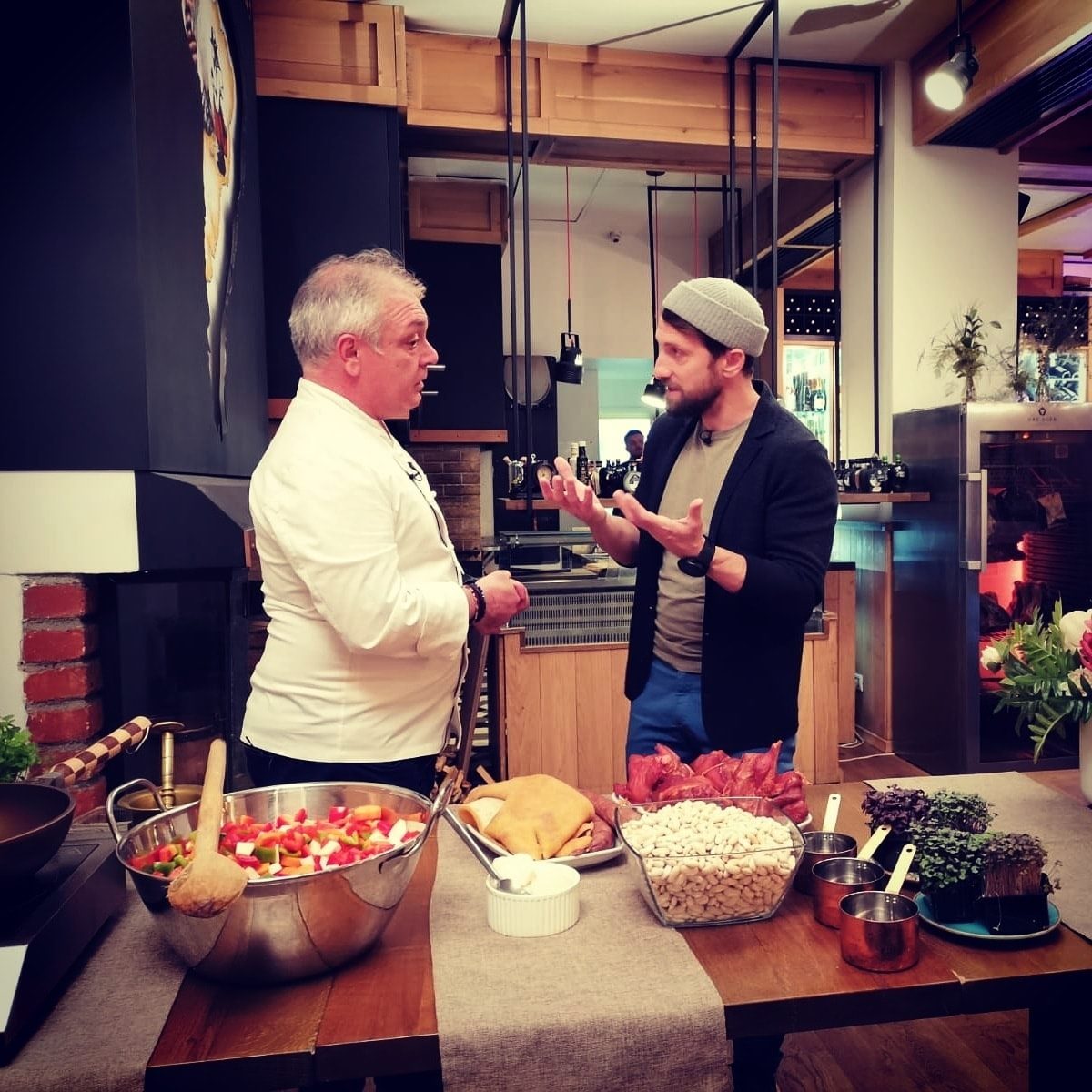 Dani Oțil stând de vorbă cu un bucătar chef în bucătăria restaurantului său