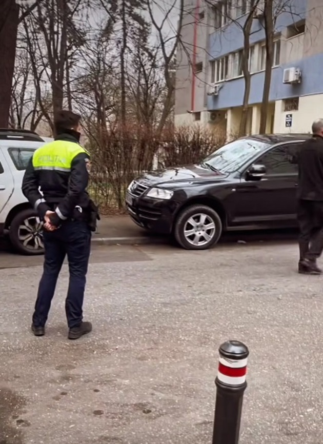 Poliția lângă mașina vandalizată a lui Lucian Viziru, parcată pe marginea drumului, lângă trotuar