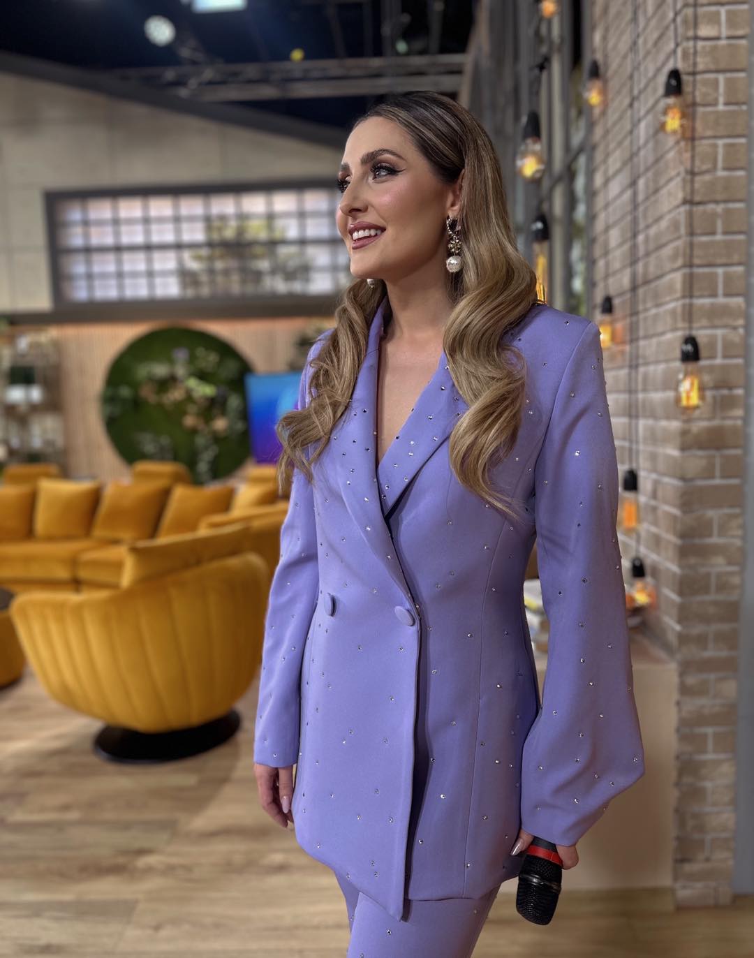 Alina Sorescu într-un costum lila format din pantaloni și sacou lung