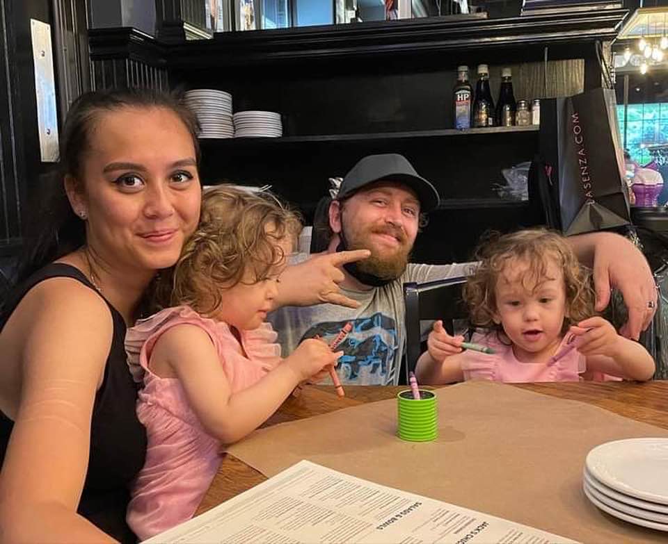 Celina Klinger și soțul ei, William Evans, alături de gemenele lor la un restaurant, stând împreună la masă, zâmbitori și fericiți