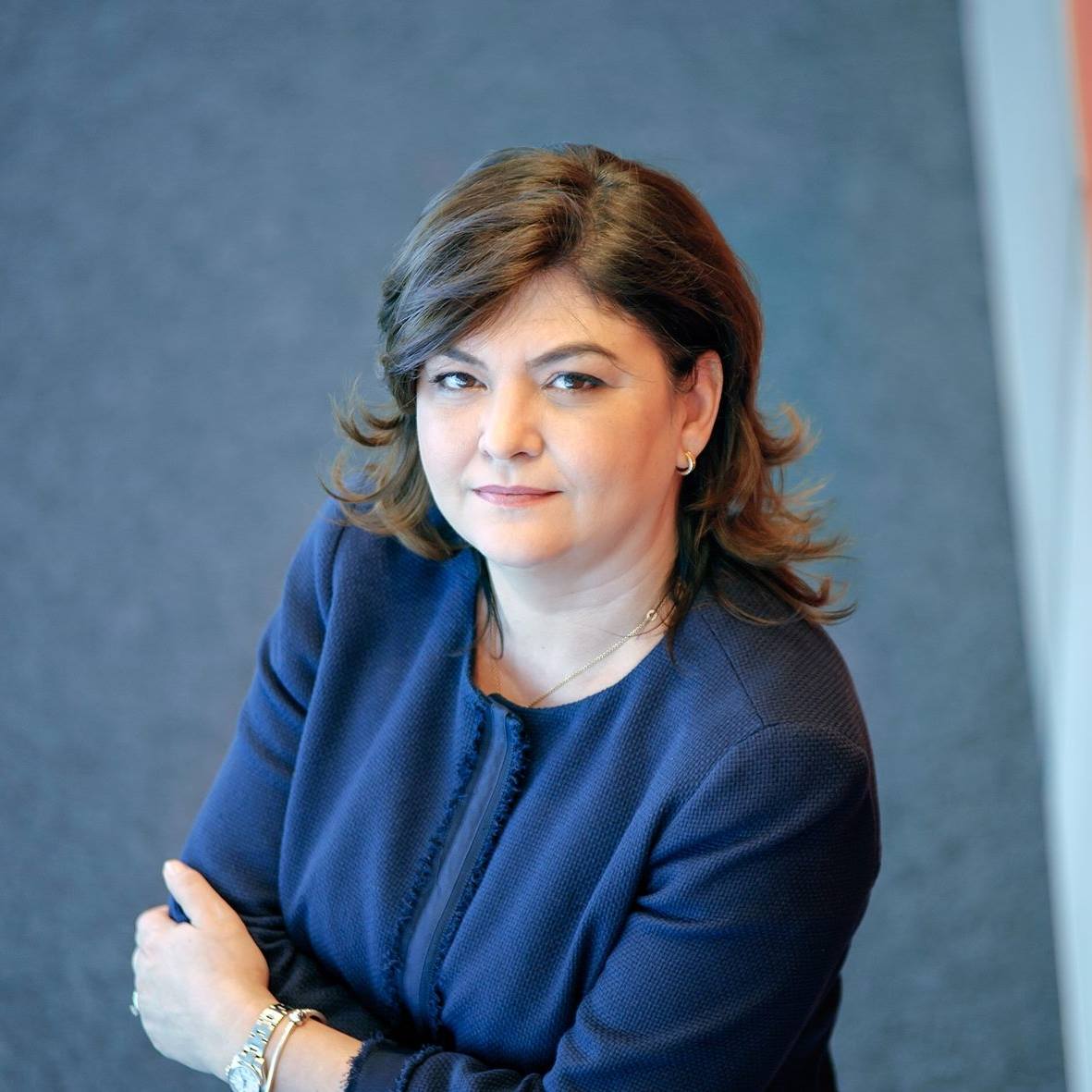 Adina Vălean, a doua soție a lui Crin Antonescu într-un sacou albastru închis, stând cu mâinile în sân