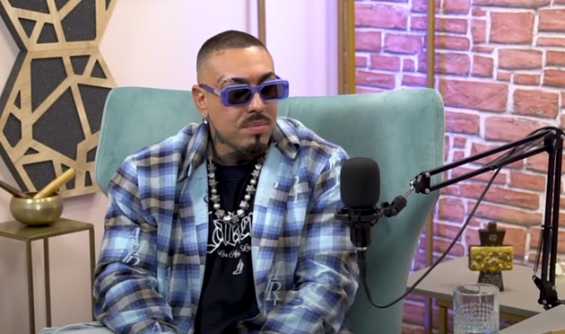 Alex Velea în timpul podcastului „Gând la gând cu Teo”, într-o cămașă colorată în carouri, cu ochelari de soare la ochi