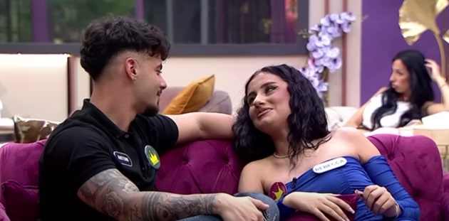 Rebecca și Antoni în „Casa Iubirii”, stând pe canapea și privindu-se în ochi