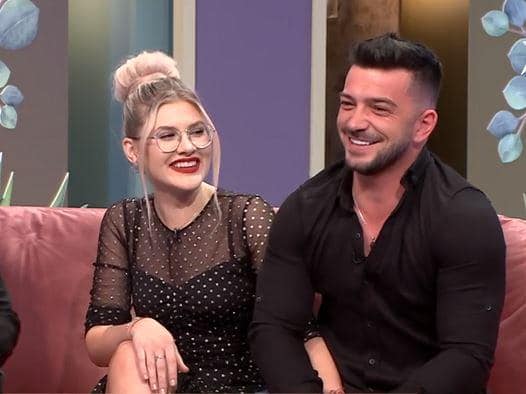 Sabrina și Andrei Perneș pe râzând împreună pe canapeaua din platoul emisiunii „Mireasa-Capriciile Iubirii”