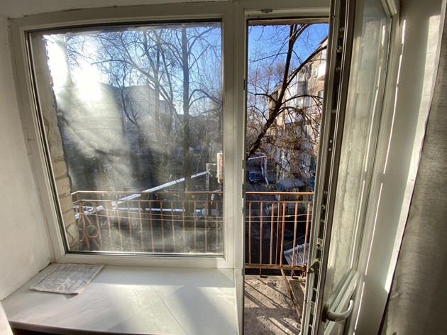 Balcon deschis cu vedere spre grădina blocului și spre blocul vecin