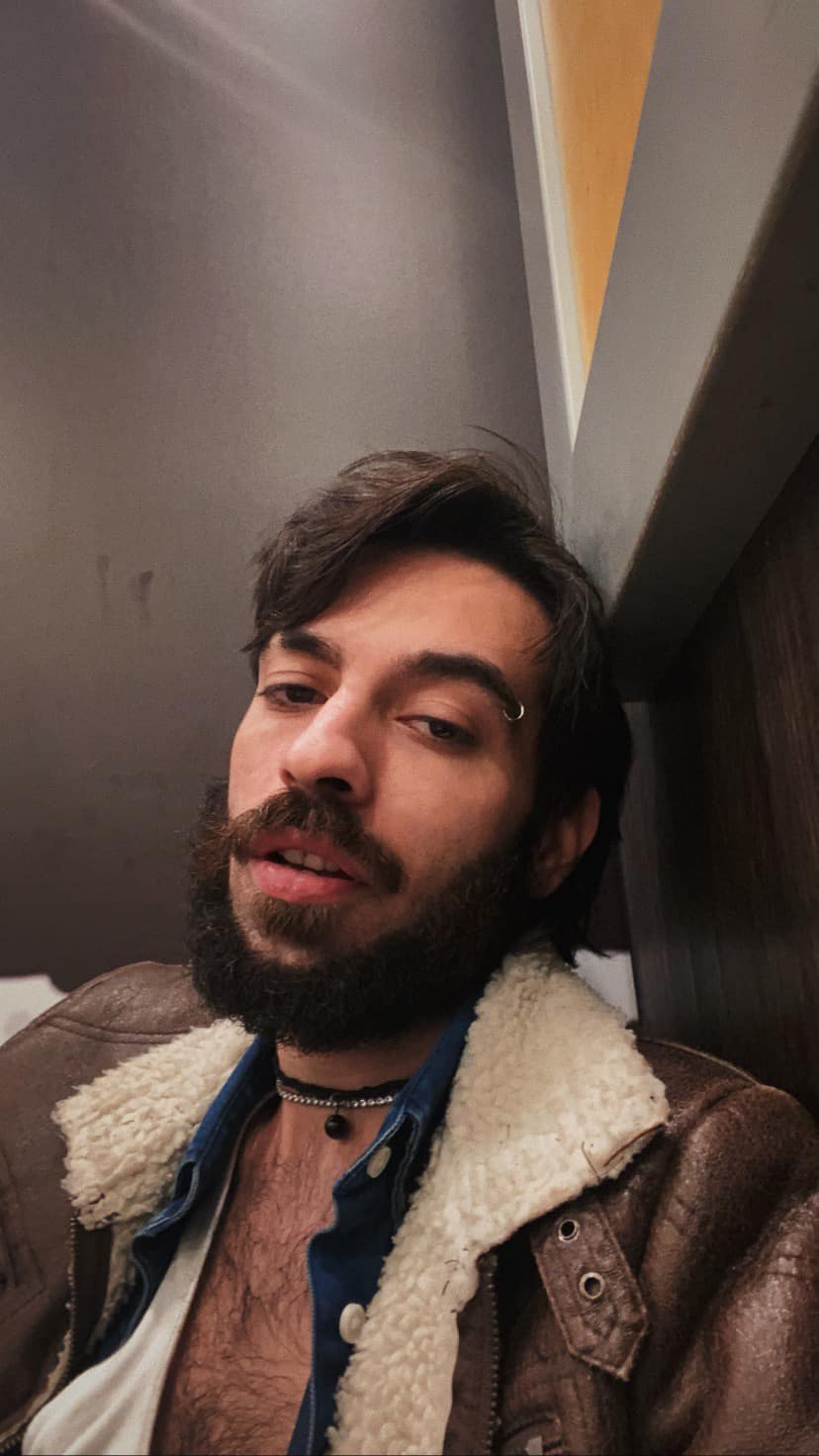 David Pușcaș, fiul adoptiv al Luminiței Anghel, purtând o cămașă descheiată și o geacă de piele cu guler de blană