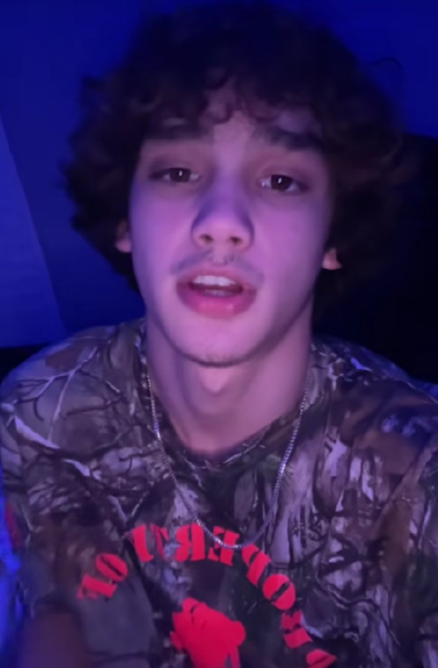 Joshua Blackledge într-un tricou cu imprimeu și cu scris, în timp ce filma un clip pentru TikTok