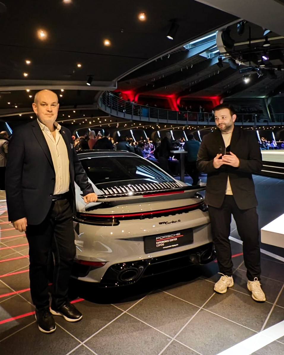 Mihai Morar alături de Călin Clej, stând amândoi lângă un Porsche alb