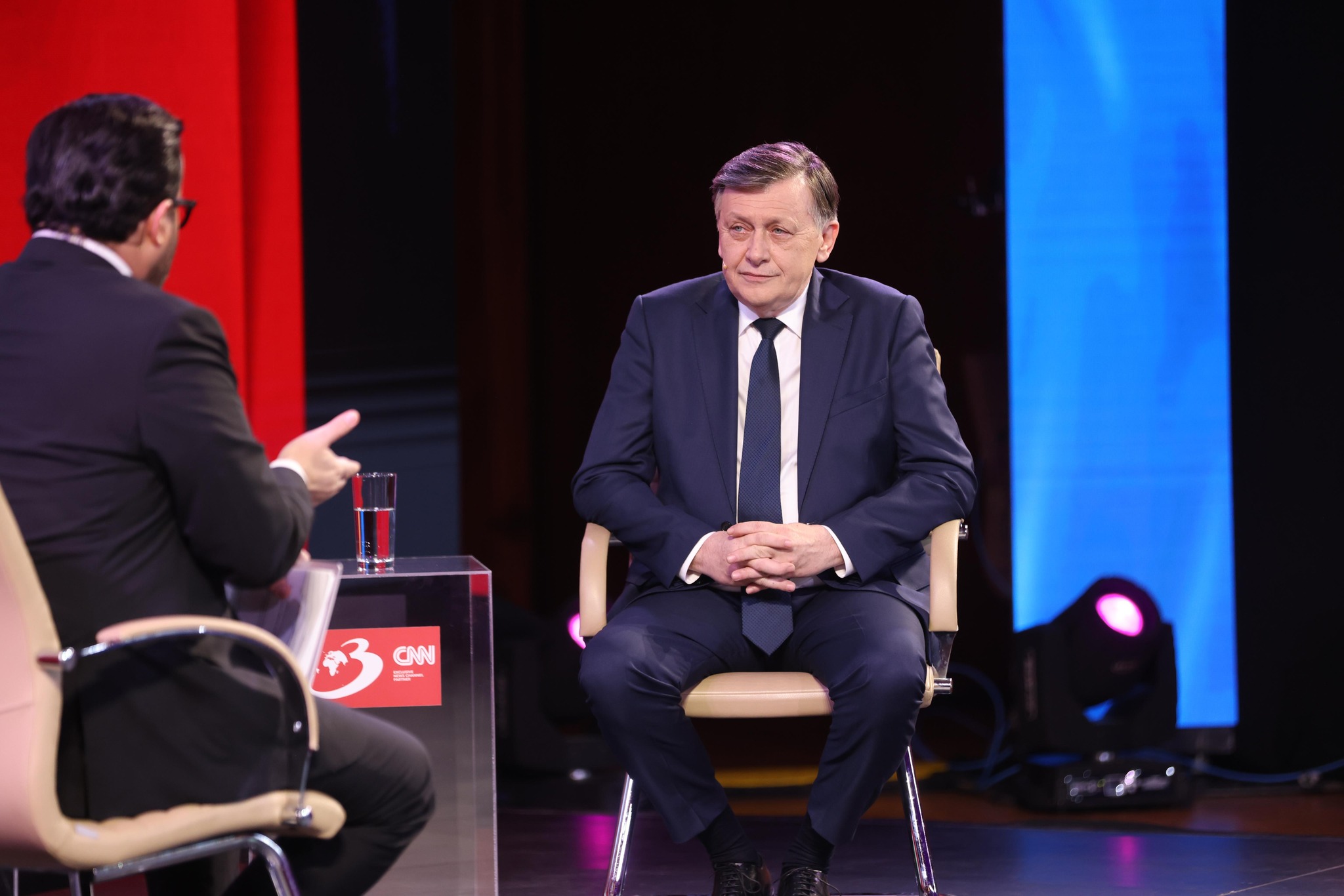 Crin Antonescu într-o emisiune la Antena 3, îmbrăcat în costum, stând relaxat pe un scaun
