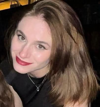 Ilaria Sula zâmbitoare, îmbrăcată în negru