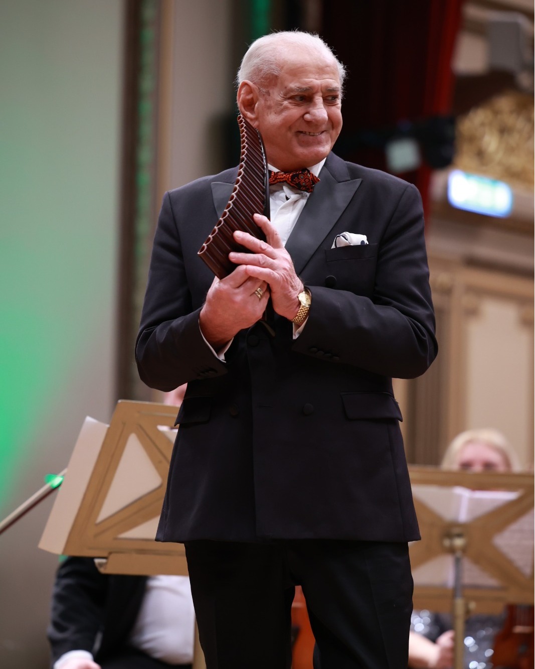 Gheorghe Zamfir pe scenă, cu naiul în mână, îmbrăcat în costum