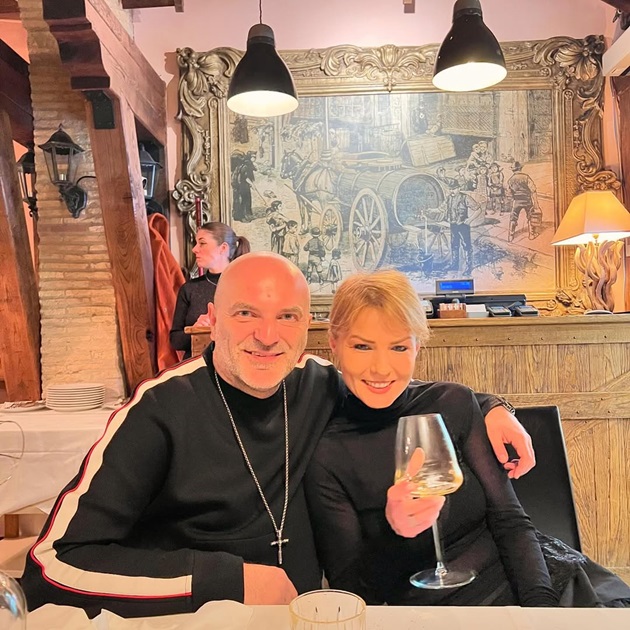 Dan Capatos alături de soția sa, Monica, la masa unui restaurant, stând îmbrățișați și savurând o băutură